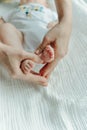 Legs newborn baby and Mama`s arms heart Royalty Free Stock Photo