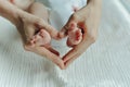 Legs newborn baby and Mama`s arms heart Royalty Free Stock Photo