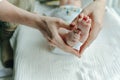 Legs newborn baby and Mama`s arms heart Royalty Free Stock Photo