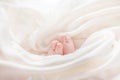 The legs of a newborn baby are wrapped in white pelic, the beginning of a new life Royalty Free Stock Photo