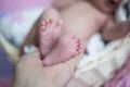 The legs of the newborn are in the hands of the mother. Royalty Free Stock Photo