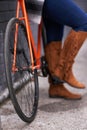 Legs, person and bicycle with standing on a road with morning transport and commute with boots. Retro, transportation