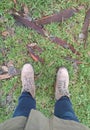 legs of person standing on grass and part of tree courtesy