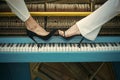 Legs on piano keyboard blue color, fashion. Royalty Free Stock Photo