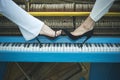 Legs on piano keyboard blue color, fashion. Royalty Free Stock Photo