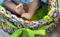 Legs of a realistic baby doll in a multi-colored basket