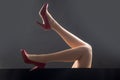 Legs in red heels. Shoes advetising. Fashion shoes style. Girl sexy slim feet.