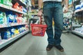 Legs and a red shopping bag for a man who buys goods in a supermarket. Select products in the market. Royalty Free Stock Photo