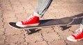 Legs in red sneakers on a skateboard. Royalty Free Stock Photo