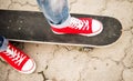 Legs in red sneakers on a skateboard. Top view. Royalty Free Stock Photo