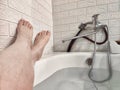 Legs during Relaxing Bath Time in a Tranquil Home Bathroom. Person enjoys a moment of relaxation, with their legs