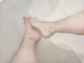 Legs during Relaxing Bath Time in a Tranquil Home Bathroom. Person enjoys a moment of relaxation, with their legs