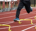 Legs of a runner in the air over yellow mini hurdles