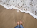 Legs in sand sea water touching feet