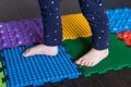 The legs of a small child on orthopedic mats. Bright surfaces for walking and forming the correct arch of the foot Royalty Free Stock Photo