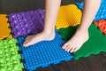 The legs of a small child on orthopedic mats. Bright surfaces for walking and forming the correct arch of the foot Royalty Free Stock Photo