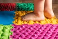 The legs of a small child on orthopedic mats. Bright surfaces for walking and forming the correct arch of the foot Royalty Free Stock Photo