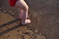 The legs of a small child on a sandy beach by the sea. A child is wetting his feet in the sea Royalty Free Stock Photo