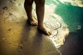 Legs of small girl walking on sea shore