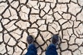 Legs in sneakers on cracked earth Royalty Free Stock Photo