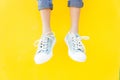 Legs sneakers on yellow background, lifestyle fashion