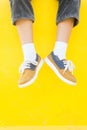 Legs sneakers on yellow background, lifestyle fashion