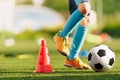 Legs of a soccer football player in blue socks and cleats running and dribbling with the ball. Royalty Free Stock Photo