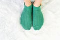 Legs in socks green colors on a white carpet Royalty Free Stock Photo