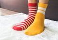 Legs in socks two colors alternate, Red and yellow side stand on white fabric floor. Royalty Free Stock Photo