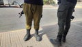 legs of a soldier in green trousers and military boots, a man with a machine gun, weapons, Israeli army Royalty Free Stock Photo