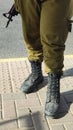 legs of a soldier in green trousers and military boots, a man with a machine gun, weapons, Israeli army Royalty Free Stock Photo