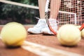 Legs of sportive girl near the tennis racquet and balls Royalty Free Stock Photo