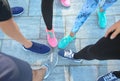 Legs of sporty young people standing in circle outdoors