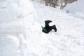 Child`s feet sticking out of the entrance to the snow house-needle Royalty Free Stock Photo