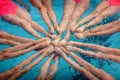 The legs of the synchronized swimmers girls peek out from the pool water and create the shape of a star in a show performance Royalty Free Stock Photo