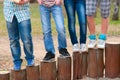 Legs of teenagers standing on wooden columns Royalty Free Stock Photo