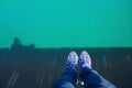 Legs of tourist wear denim sitting on seaside bridge in mood relax.