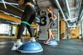Legs training. Two athletic women in sportswear exercising with resistance fitness band at crossfit gym, using special