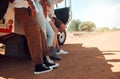 Legs, travel and friends on a road trip with a car for holiday in Kenya together during summer. Feet of a group of