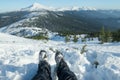 Legs of the traveler in hiking boots with snow gaiters in the snowy mountains