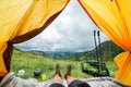 Legs of the traveler in hiking boots in a tent outdoors