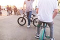 Company bmx riders in a skate park on the background of the sunset. Training young people on a bmx bike. bmx concept