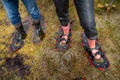 Legs of two tourists in rubber boots and marshes, top view