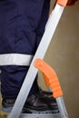 Legs of a uniformed worker on stepladder