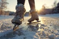 Legs of unrecognizable woman ice skating outdoors at sunset, close up Royalty Free Stock Photo