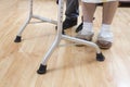 Legs of a very old woman in white socks and slippers. The old lady learns to walk with the help of a rehabilitation walker. Royalty Free Stock Photo
