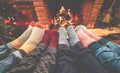 Legs view of happy family lying down next fire place wearing warm wool socks - Winter, holiday, love and cozy concept - Focus on Royalty Free Stock Photo