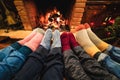 Legs view of happy family wearing warm socks in front of fireplace - Focus on left socks