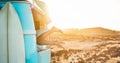 Legs view of happy surfer girl inside minivan at sunset - Young woman having fun on summer vacation - Travel,sport and nature Royalty Free Stock Photo