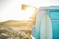Legs view of happy surfer girl inside minivan at sunset - Young woman having fun on summer vacation - Travel,sport and nature Royalty Free Stock Photo